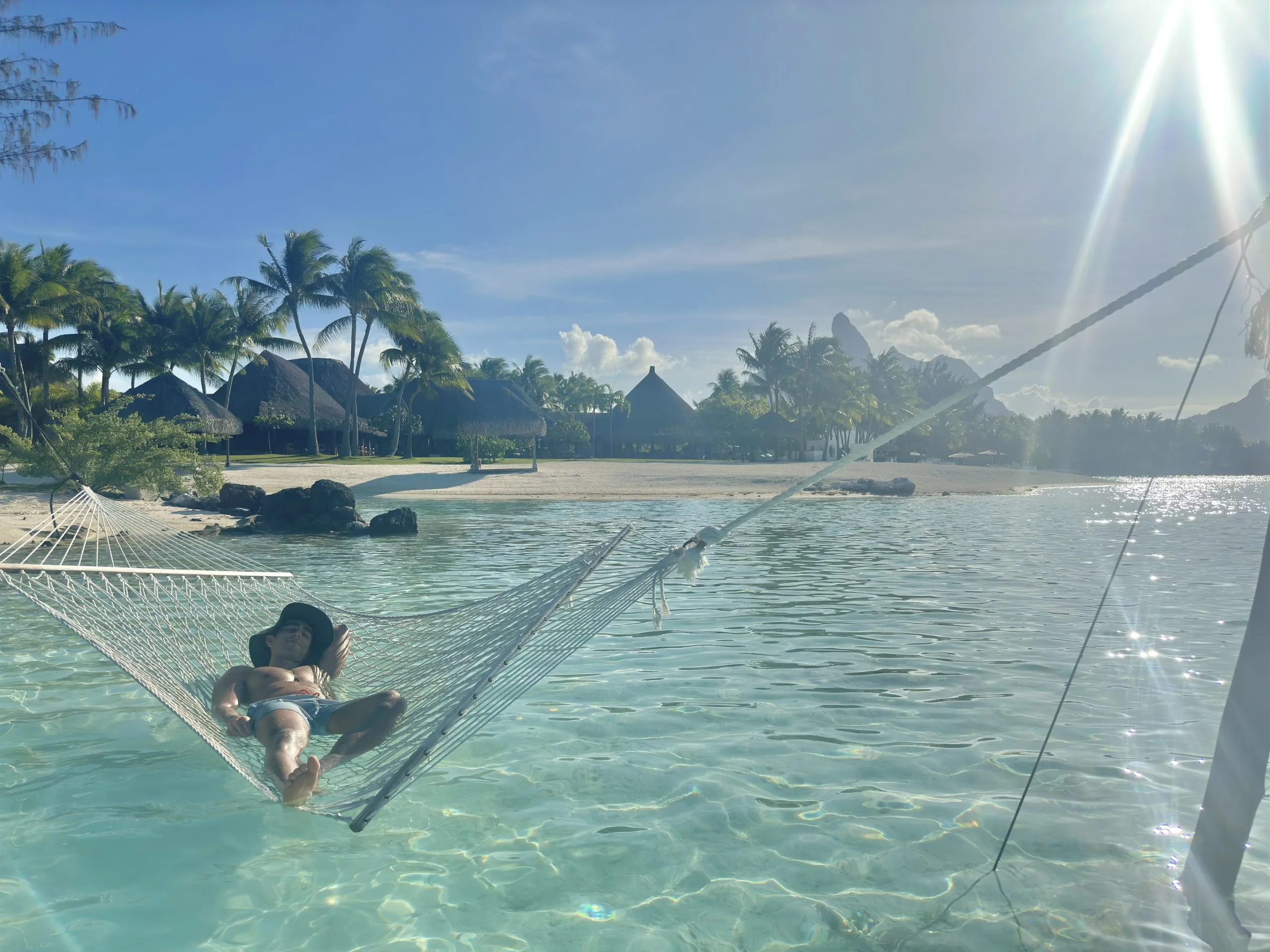 Author of this post (Jonny) in Bora Bora sitting in water Hammock like in the White Lotus show