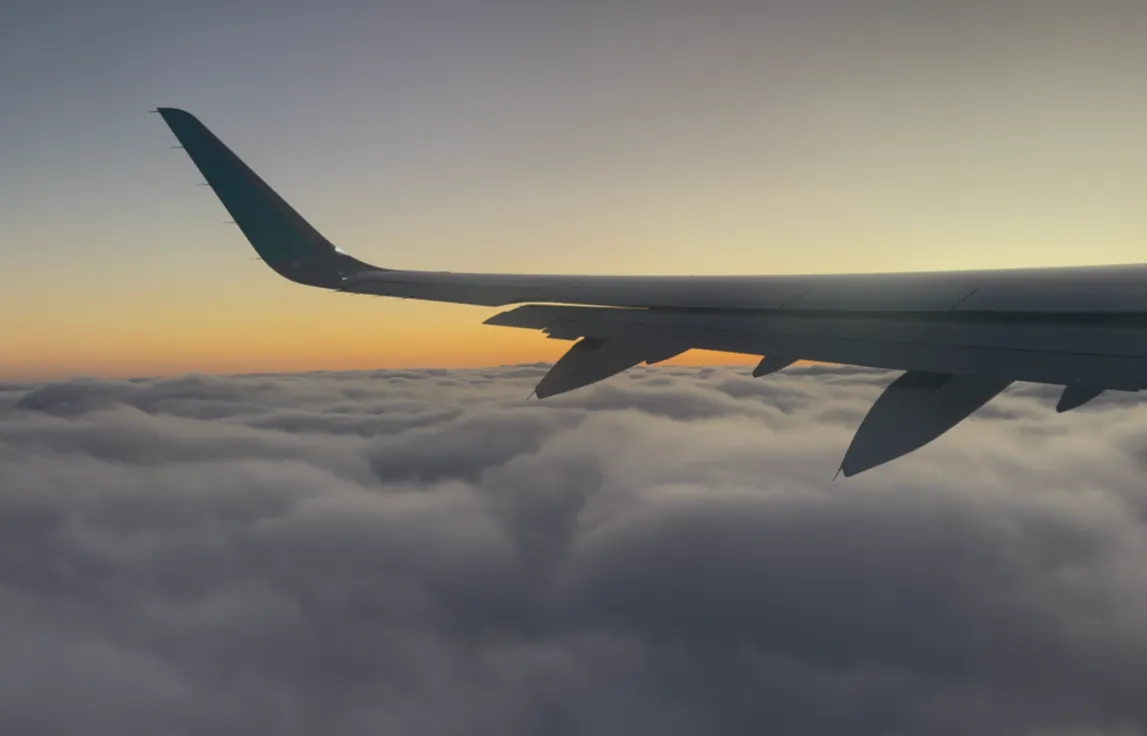 Photo of an airplane wing at sunset - Skincare in the Sky: 4 Steps to Avoid Breakouts When Flying