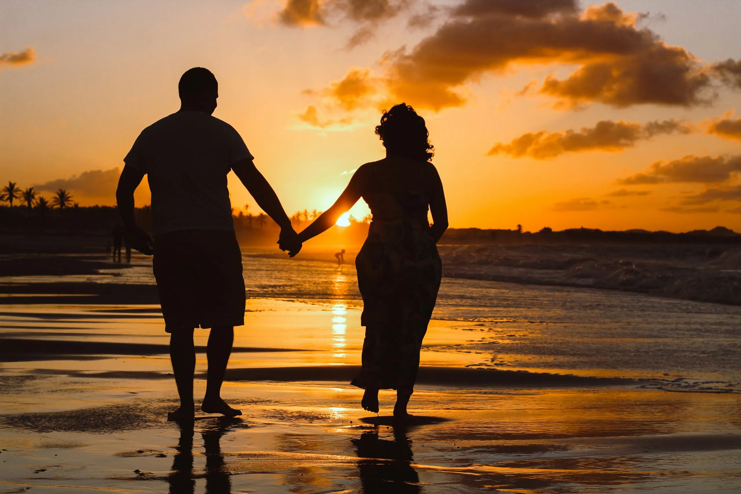 Couple holding hands on the beach