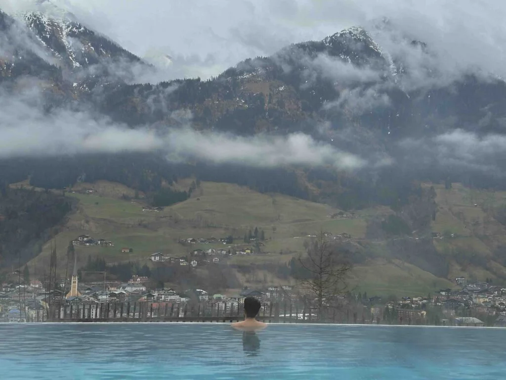 Founder of Imperfect Nostalgia in a pool looking at the alps